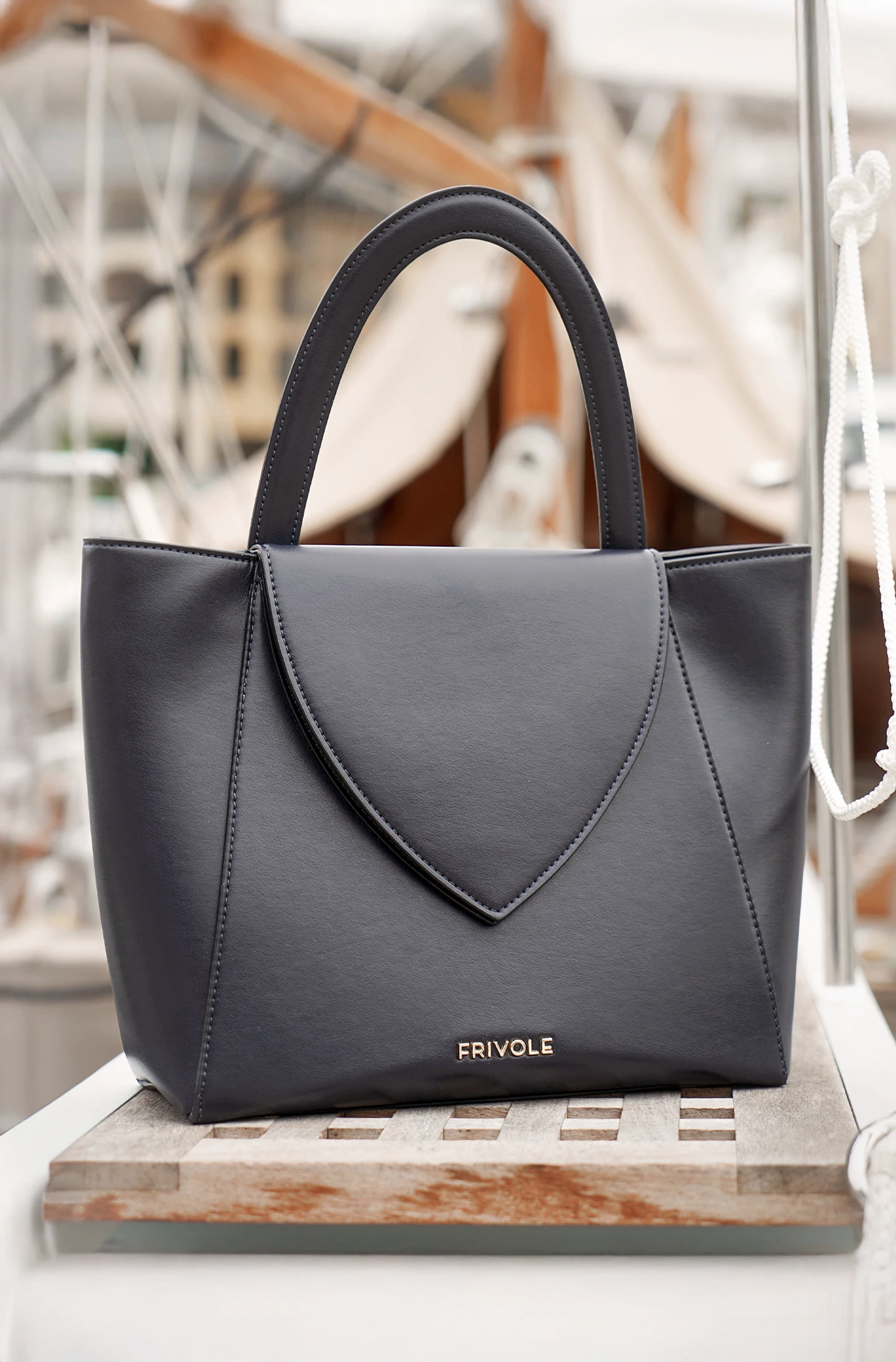 Sac à main Désinvolte bleu abyssal posé sur un bateau, vue de face.